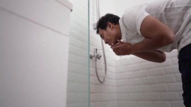 Genç Müslüman adam duadan önce abdest alıyor.