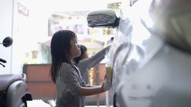 Mutlu çocuk babasının arabasını yıkıyor.