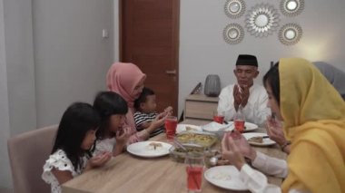 Müslüman insanlar iftar sırasında aileleriyle birlikte dua ediyorlar.