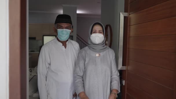 Zralé páry nosí masku obličeje stojící u předních dveří svého domu — Stock video