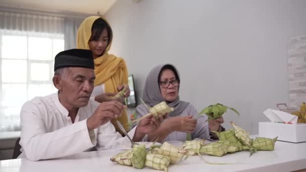 Muslimský pár a dcera výroba ketupat pro eid fitr mubarak — Stock video