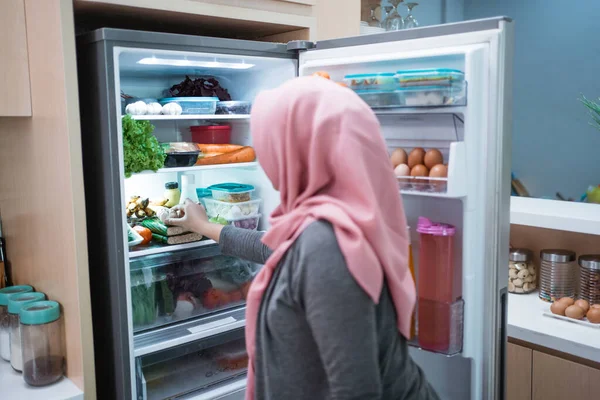 muslim woman open fridge door and getting ready to cook