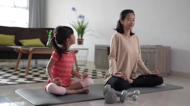 Matka robi ćwiczenia jogi w domu z córką razem — Wideo stockowe