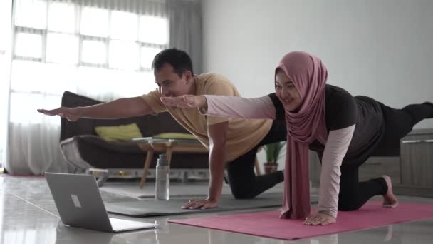 Muslim fitness couple stretching and looking at online video tutorial — Stock Video