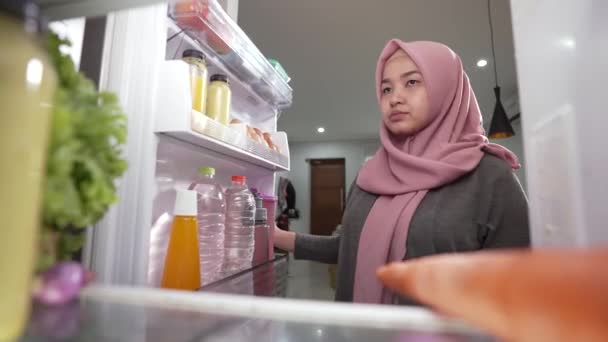 穆斯林妇女打开冰箱门，准备做饭吃晚饭 — 图库视频影像