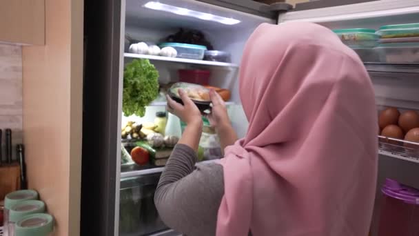 Muslimin öffnet Kühlschranktür und bereitet sich auf Abendessen vor — Stockvideo