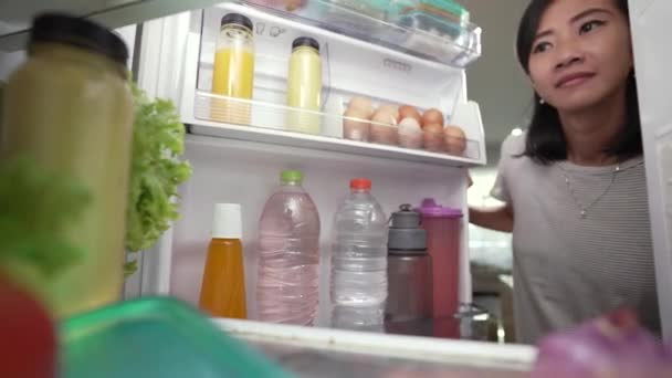 Casa esposa tomando um pouco de bebida da geladeira. atirar a partir de dentro — Vídeo de Stock