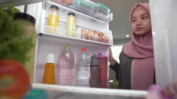 Muslimin öffnet Kühlschranktür und bereitet sich auf Abendessen vor — Stockvideo