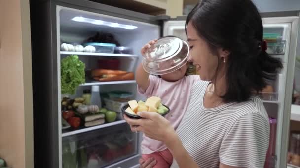 幼い赤ちゃんを連れて一緒に果物を食べる母親 — ストック動画