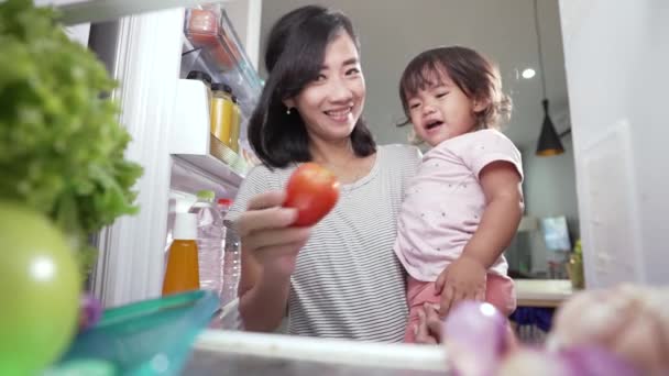 亚洲母亲抱着女儿给她一些食物，但她拒绝了 — 图库视频影像