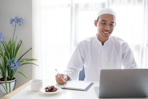 穆斯林商人坐在桌子上使用笔记本电脑工作 — 图库照片