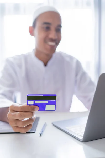 Musulmán asiático hombre utilizando tarjeta de crédito para el pago en línea tienda —  Fotos de Stock