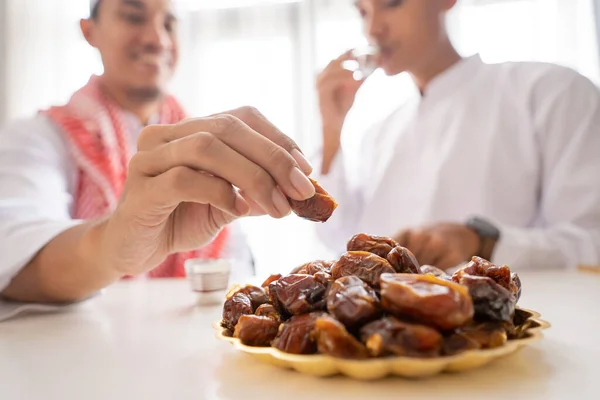 Muslim berbagi semangkuk tanggal sambil menikmati makan malam iftar bersama — Stok Foto