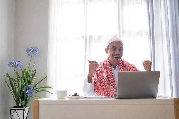 成功したビジネスマンはノートパソコンを使いながら腕を上げ — ストック写真