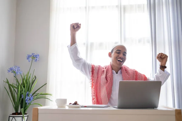 Erfolgs-Geschäftsmann hebt den Arm, während er Laptop benutzt — Stockfoto
