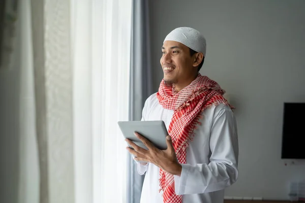 Pengusaha muslim tersenyum sambil menggunakan tablet pc — Stok Foto