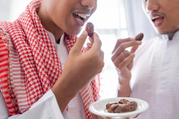 Muslim berbagi semangkuk tanggal sambil menikmati makan malam iftar bersama — Stok Foto