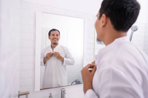 Homem muçulmano olhando para o espelho e se vestir antes de ir para a mesquita — Fotografia de Stock
