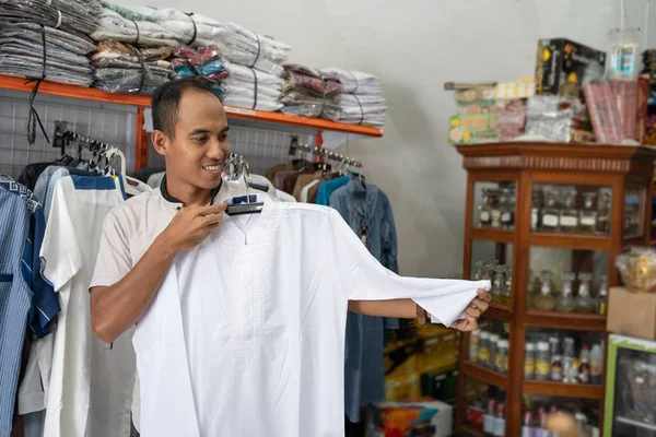 Jovem asiático muçulmano homem compras para roupas na loja — Fotografia de Stock
