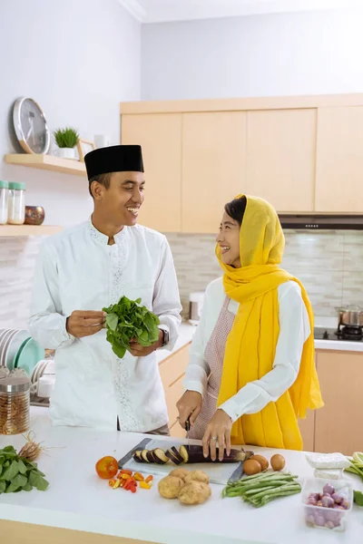 Ο σύζυγος βοηθάει τη γυναίκα του να μαγειρέψει μαζί στην κουζίνα. — Φωτογραφία Αρχείου