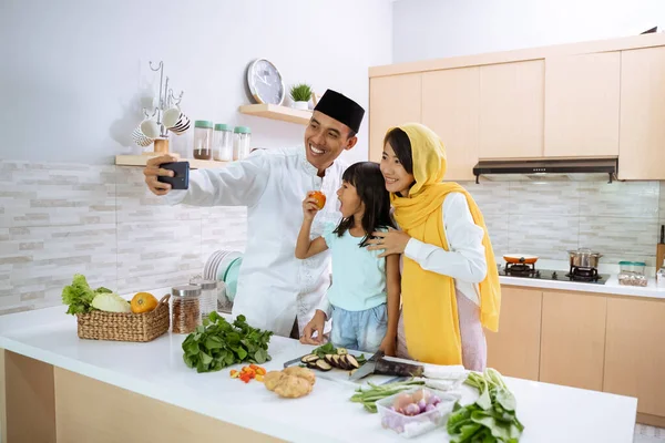 Muslim keluarga Asia mengambil selfie selama persiapan makan malam iftar — Stok Foto