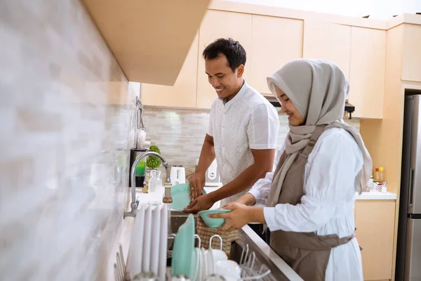 Щаслива мусульманська молода пара миє посуд разом — стокове фото