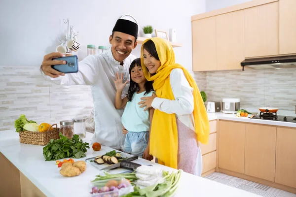 Muslim keluarga membuat video, selfie atau panggilan telepon bersama-sama selama iftar makan malam persiapan — Stok Foto