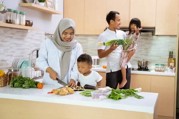 Muslim keluarga dengan dua anak memasak bersama-sama di rumah mempersiapkan untuk makan malam iftar — Stok Foto
