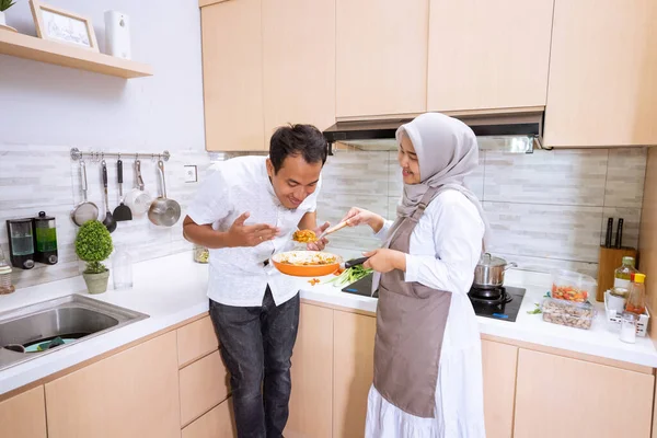 Азіатська мусульманська пара насолоджується приготуванням їжі разом на кухні — стокове фото