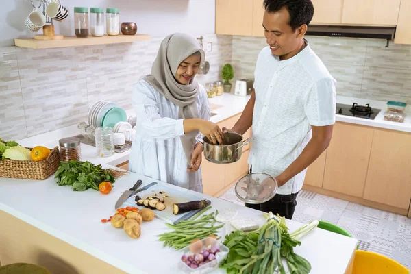 Manžel pomoci jeho žena vaření společně v kuchyni — Stock fotografie