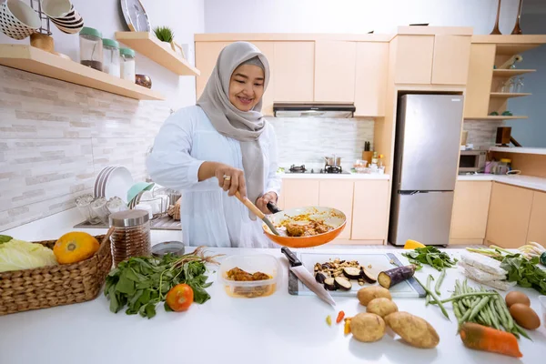 Женщина с хиджабом готовит у себя дома на кухне на ужин — стоковое фото