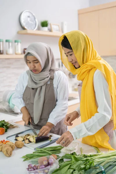 Dos atractiva joven musulmana mujer preparando iftar cena juntos — Foto de Stock