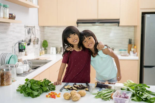 Dos hermosa niña preparando y cocinando la cena en la cocina — Foto de Stock