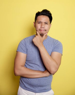 Sıradan genç adam gülümse. Düşüncelerini çene ve bir elin karnında tut.