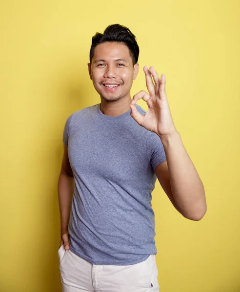 Uomo che indossa casual t-shirt sorriso espressione mostrando segno OK con la mano — Foto Stock