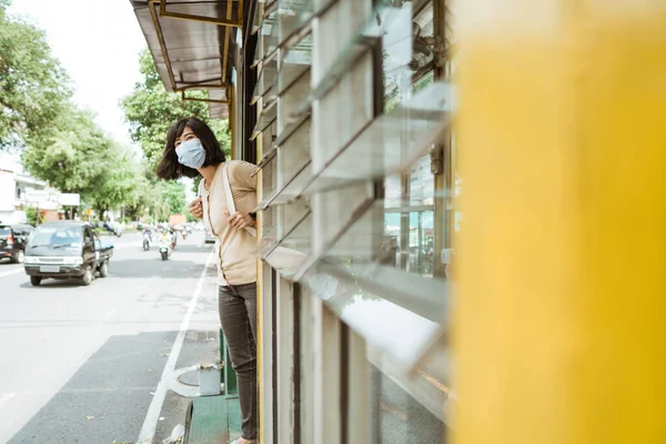 Woman wearing a mask stands waiting for the bus — Stock Photo, Image