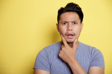 Sıradan genç adam gülümse. Çene tutarak düşünme fikri.