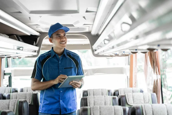 男性バス乗組員のクローズアップは棚を確認しながらデジタルタブレットを使い — ストック写真