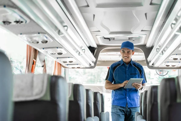 A bus crew member in uniform and a hat using a digital tablet while checking — Stock Photo, Image