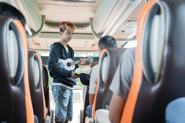 Преступник с помощью удушающего инструмента и шляпы просит у пассажиров автобуса деньги — стоковое фото
