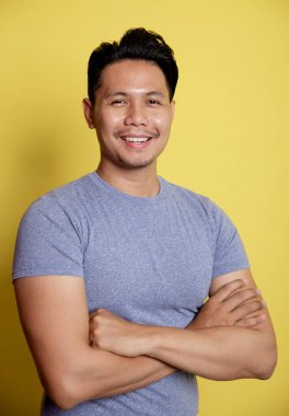 Yaklaş genç adam gülümse ve kollarını birleştir.