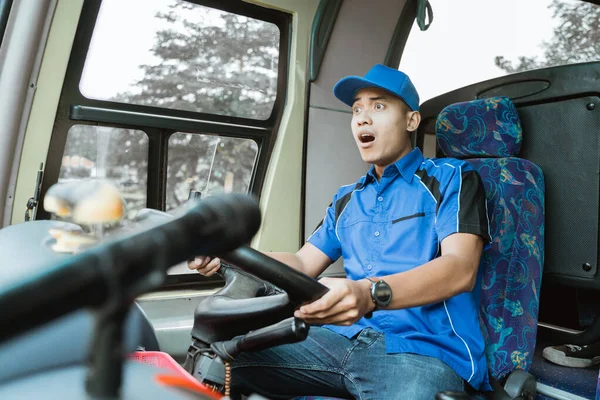 青い制服の男のバス運転手が運転中にショックを受ける — ストック写真