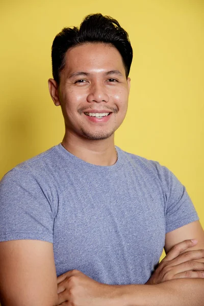 Yaklaş genç adam gülümse ve kollarını birleştir.