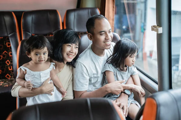 Le père et la mère ont tenu leurs deux enfants assis sur le banc d'autobus — Photo