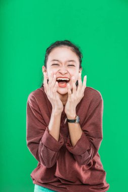 Genç Asyalı kadın ağzı açık ve şaşkınlıkla ellerini kaldırıyor.