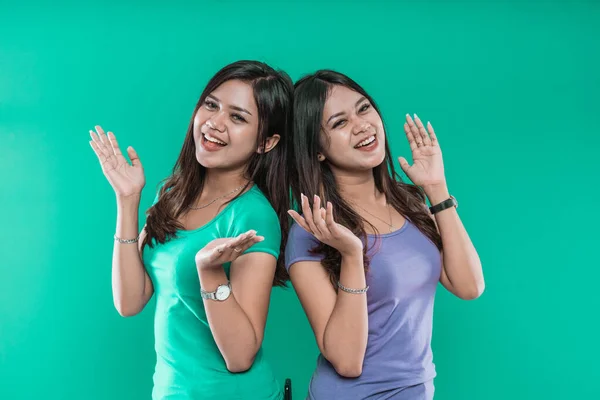 Portrait of beautiful young girls smiling together and waving at camera — Stock Photo, Image