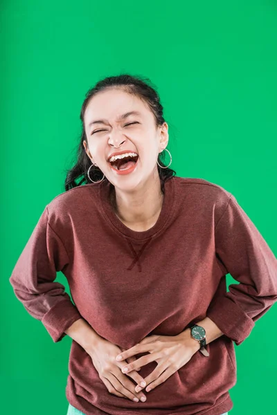 Jovem asiático mulher vestindo suéter feliz rindo enquanto segurando seu estômago — Fotografia de Stock