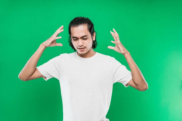 Handsome Asian man with a flustered expression on the face while raising two hands at the side of the head — Stock Photo, Image