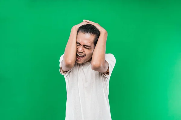 Portrait of Asian man with screaming headache holding his head — Stock Photo, Image