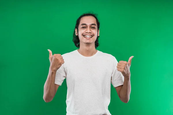 Hombre guapo levantando dos manos mientras muestra los pulgares a la cámara con una sonrisa — Foto de Stock
